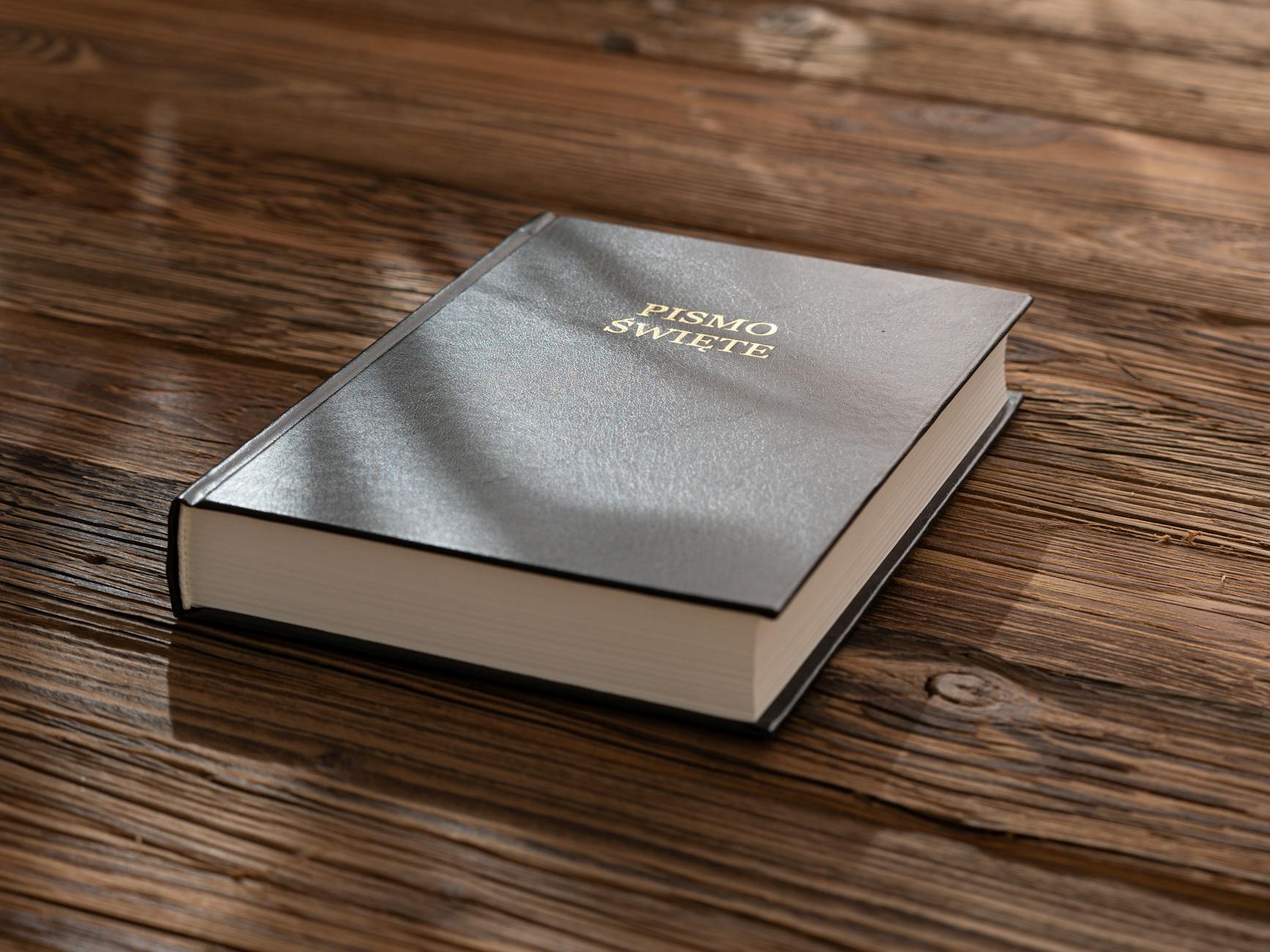 Polska Biblia na drewnianym stole w ciepłym świetle słońca